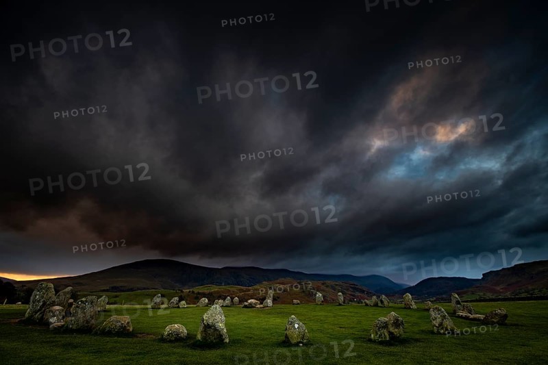 Stone circle with dramatic dark cloud sky