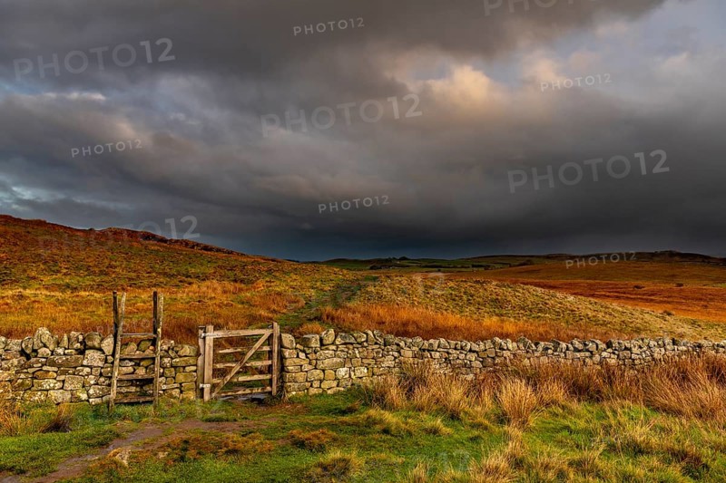 Stone wall in autumn landscape with dark sky