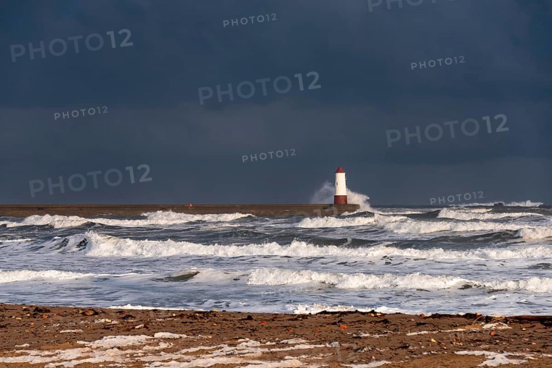 Berwick Lighthouse with strong surf and dark cloudy sky