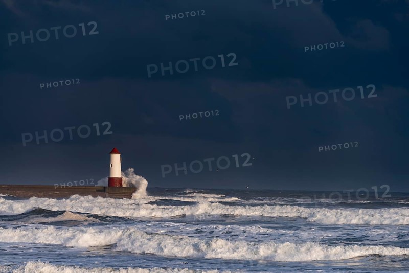 Berwick Lighthouse with strong surf and dark cloudy sky