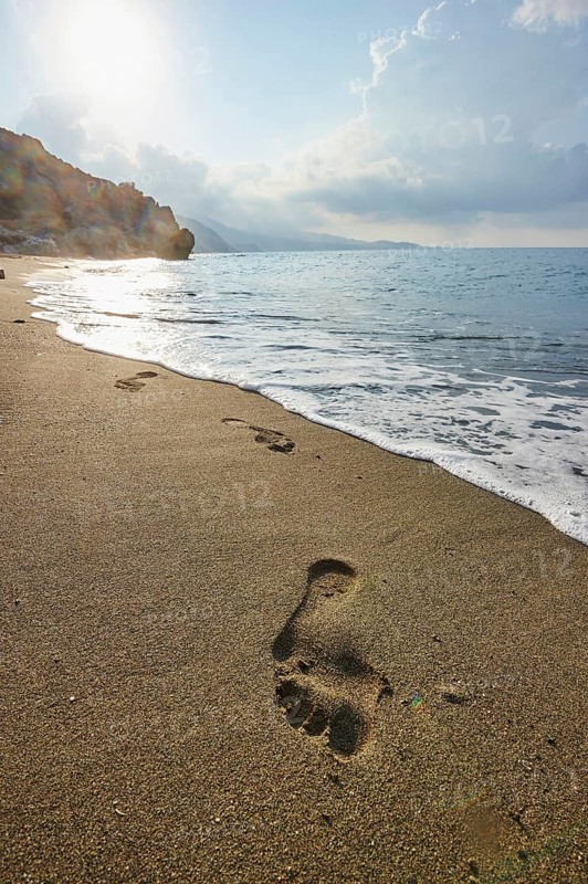 Footsteps in the wet sand at shore