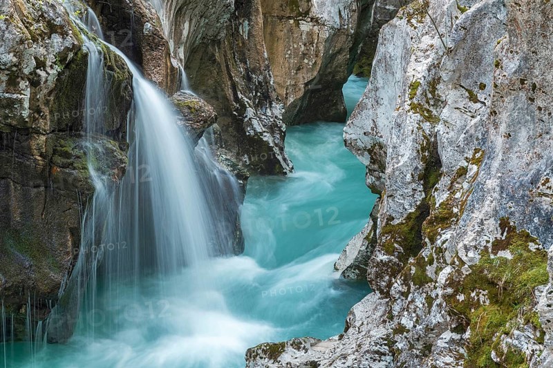 Emerald green wild river Soca flows through narrow canyon