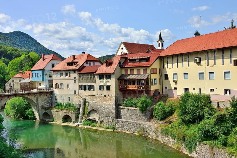 City view Skofja Loka with buildings from the 14th century and the Capuchin bridge over the river Sora
