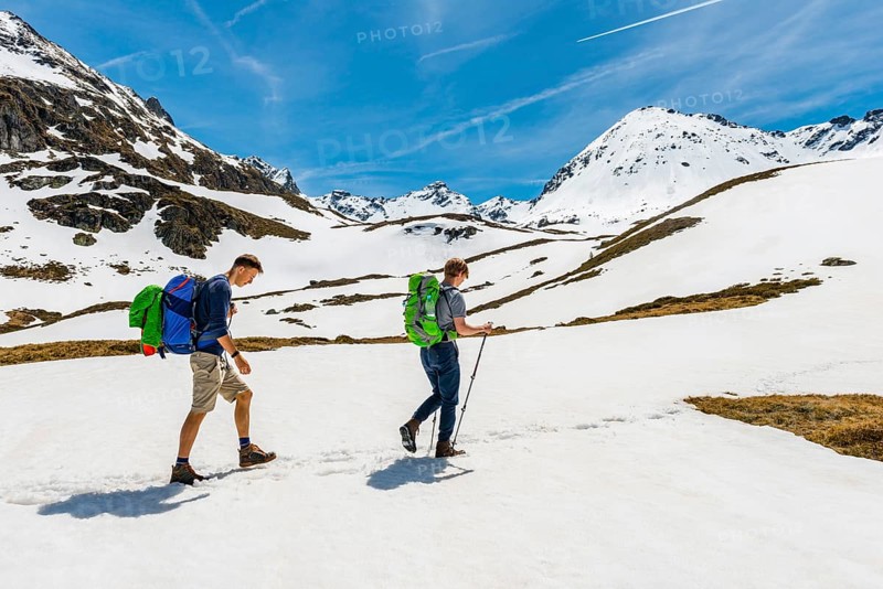 Two hikers walk over snowfield