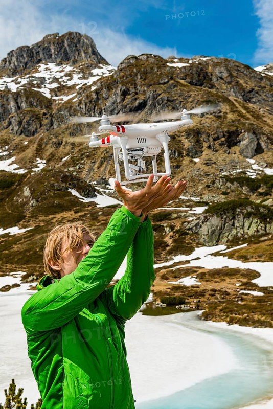 Young man catches a drone in the mountains