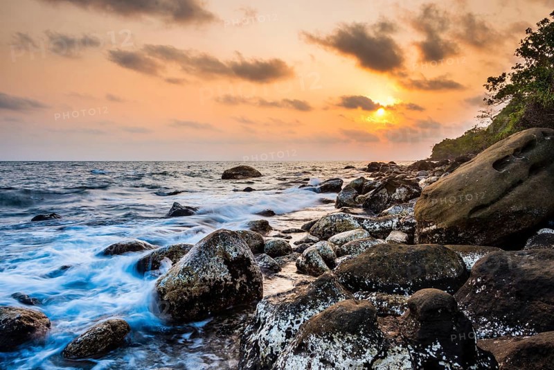 Sunset at rocky coast near Long Beach in Sok San village on Koh Rong island