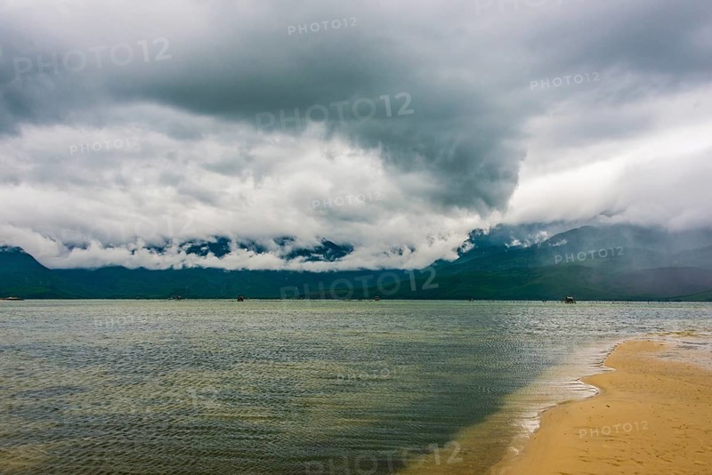 Sandy beach with dramatic stormy clouds in Hue