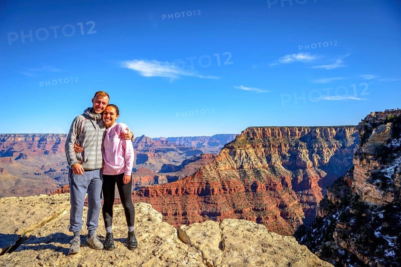 Couple embraces in front of the gigantic gorge of the Grand Canyon