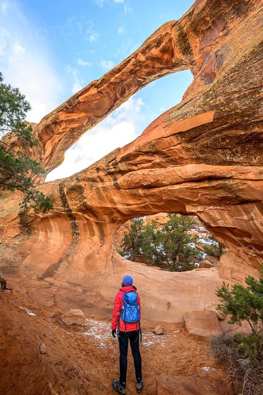 Hiker in front of Double O Arch