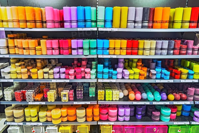 Shelves with different coloured candles in the supermarket