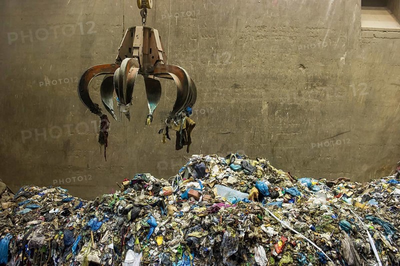 Gripper arm over pile of trash