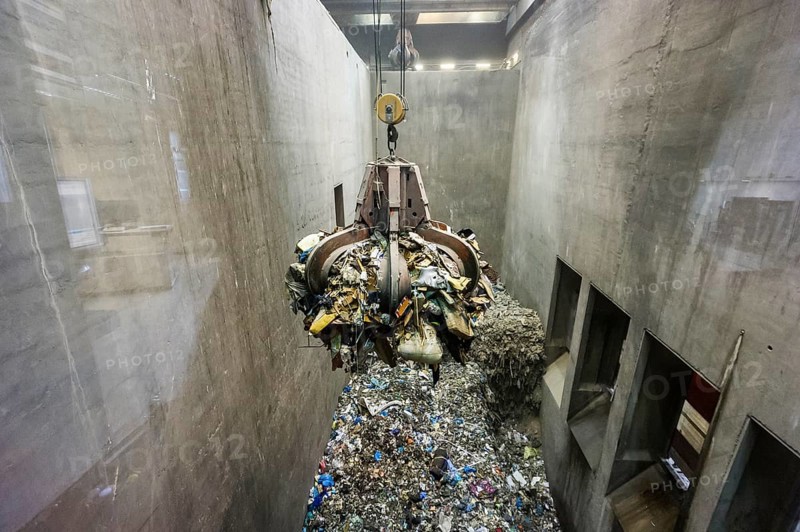 Gripper arm over pile of trash