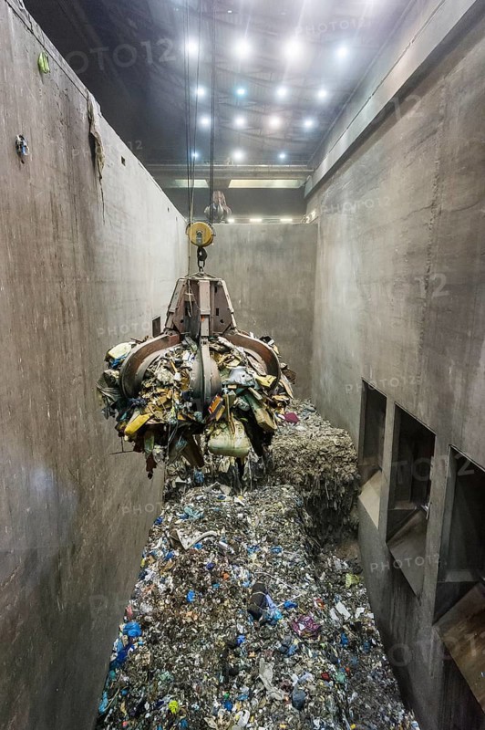 Gripper arm over pile of trash