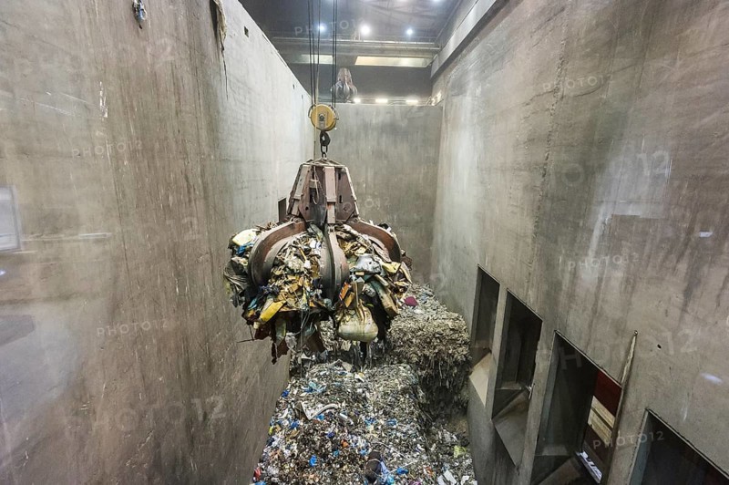 Gripper arm over pile of trash
