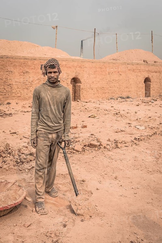 Worker with shovel in a brickyard
