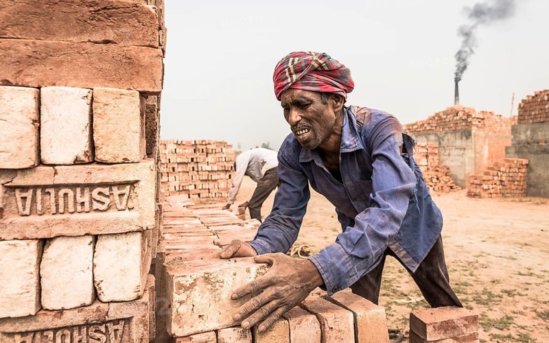 Brick factory worker stacks bricks