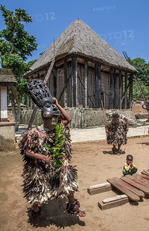 Dancers in traditional clothing wearing carved masks