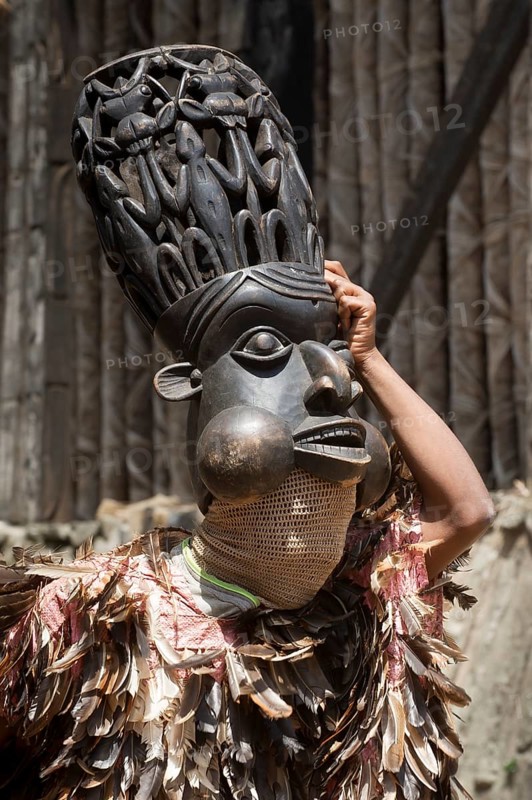 Dancer in traditional clothing wearing carved mask