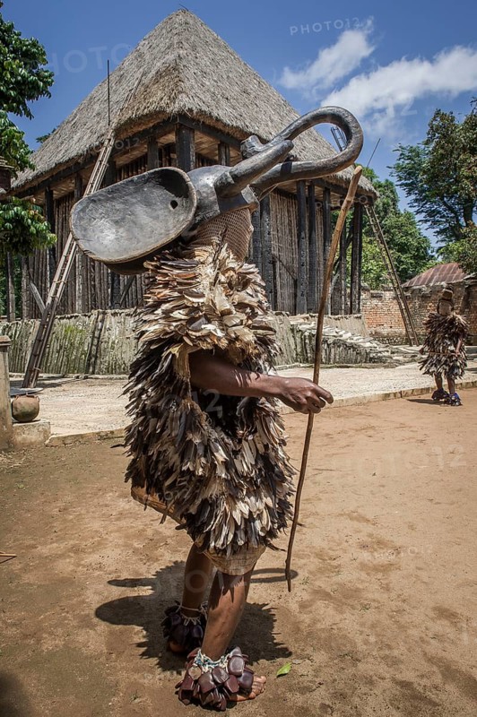 Dancer in traditional clothing wearing carved mask
