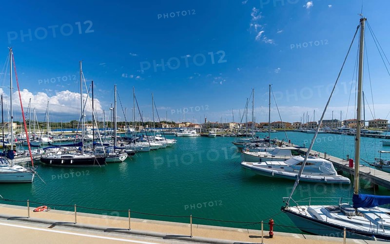 Sailing and motor boats are anchored in the harbour