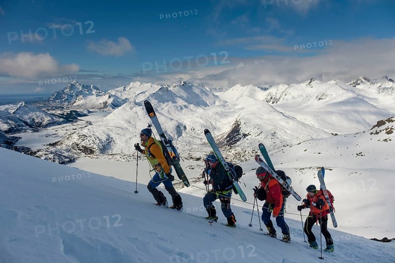 Mountain guide leads a rope team of ski mountaineers on Blatinden