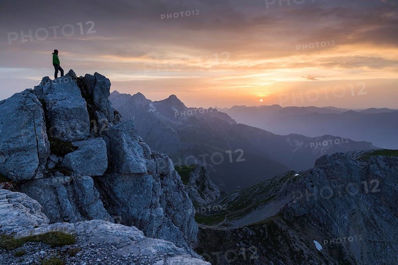 Hiker on top of the Dreitorspitze at sunset