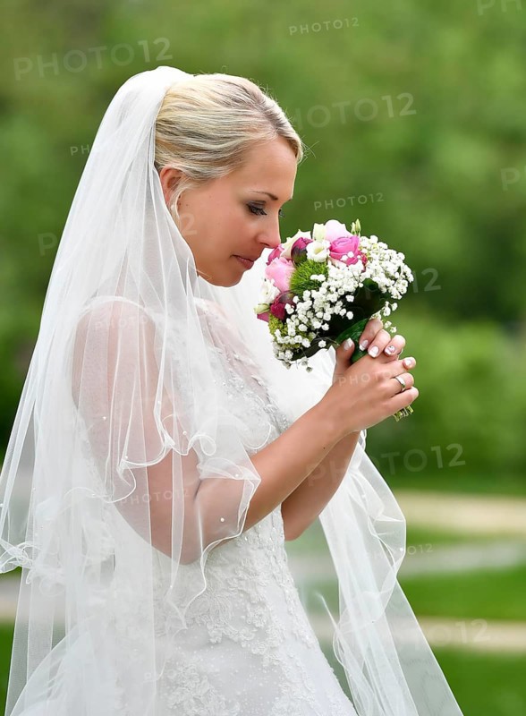 Bride in wedding dress with bridal bouquet and veil
