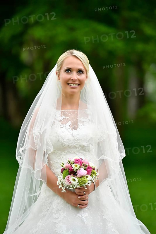 Bride in wedding dress with bridal bouquet and veil