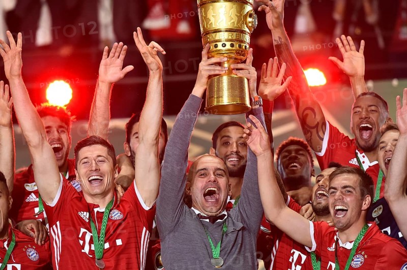 Coach Josep Pep Guardiola lifting the DFB Cup in the air