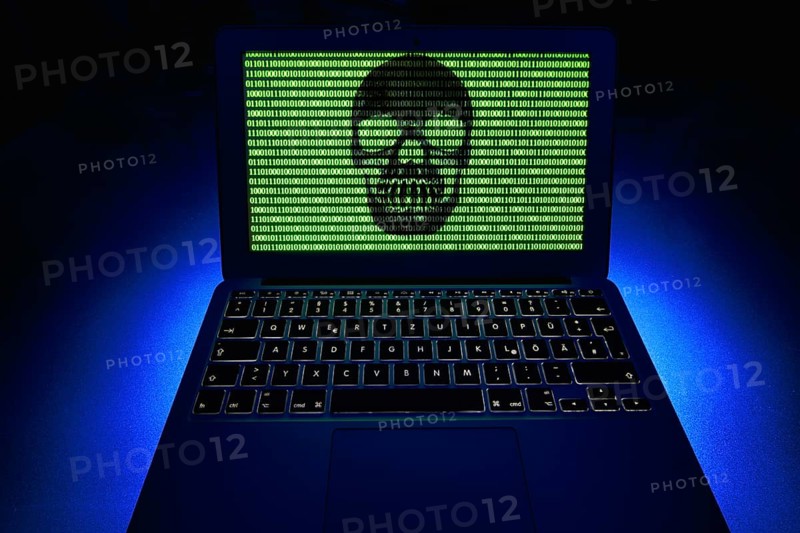 Laptop with skull and crossbones and binary numbers on screen