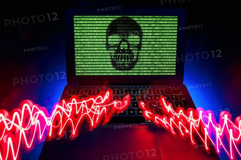Laptop with skull and crossbones and binary numbers on screen