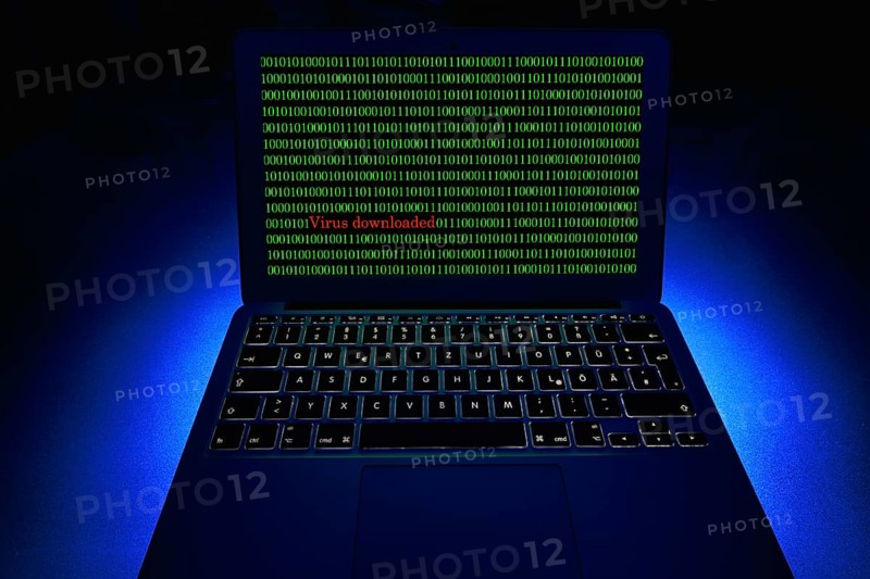 Laptop with binary numbers on screen. Symbol image malware