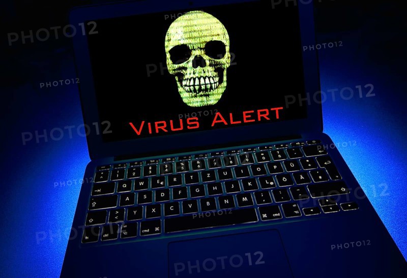 Laptop with skull and crossbones and binary numbers on screen