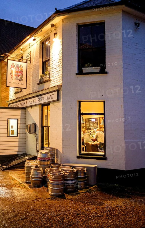 Lights at a pub with barrels outside the entrance