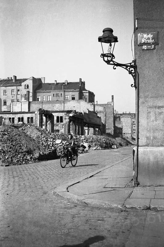 Woman on a bicycle riding through ruins