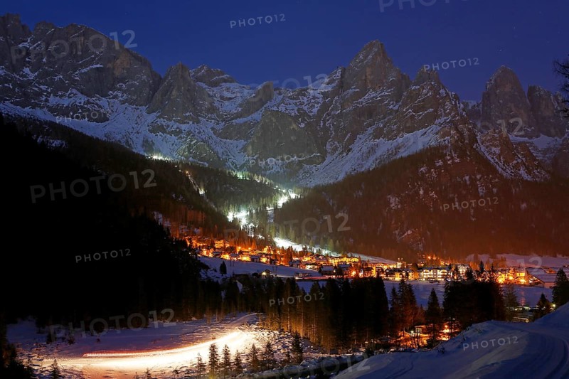 San Martino di Castrozza in front of a snow-covered mountain backdrop in winter