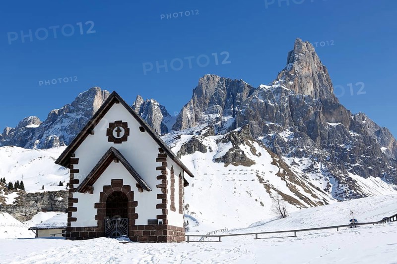 Chapel at the mountain pass Passo Rolle with snow
