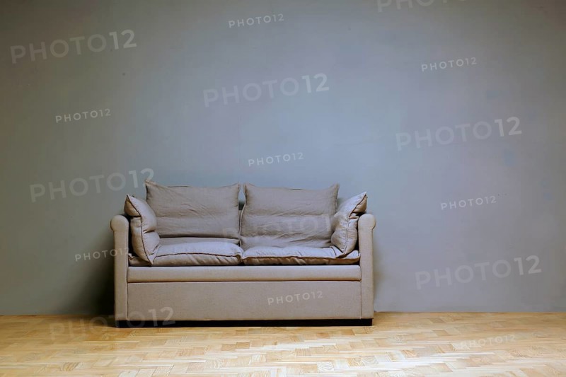 Lonely couch in front of a wall in the room