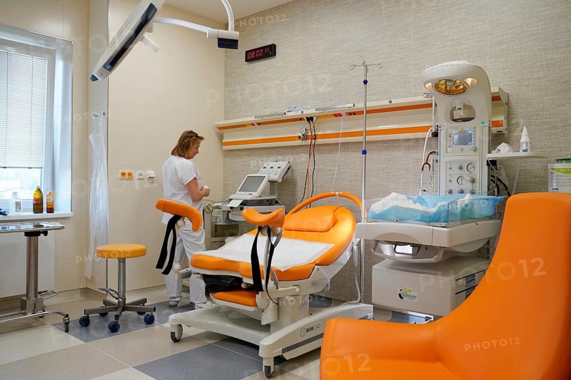 Nurse in an empty modern delivery room with birthing chair