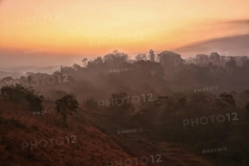 Sunrise with morning haze over wooded hills