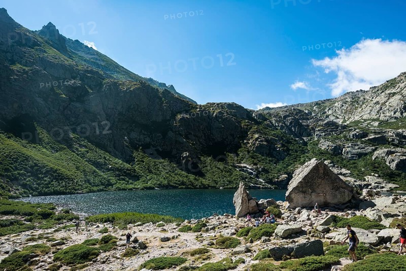 Hikers at mountain lake Lac de Melo