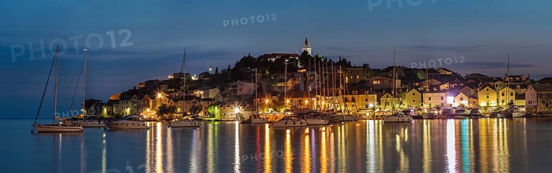 View of the town with sailing boats and lights reflecting in the water