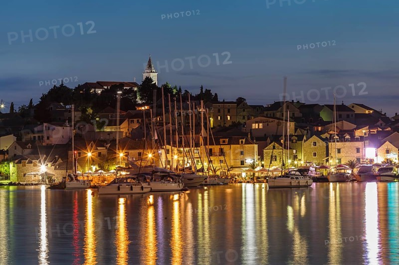 View of the town with sailing boats and lights reflecting in the water