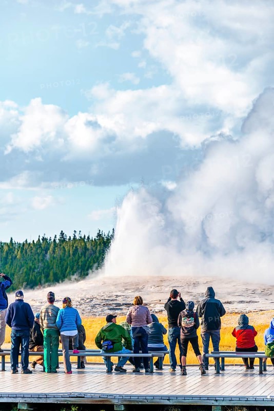 Tourists observe eruption of Old Faithful Geyser