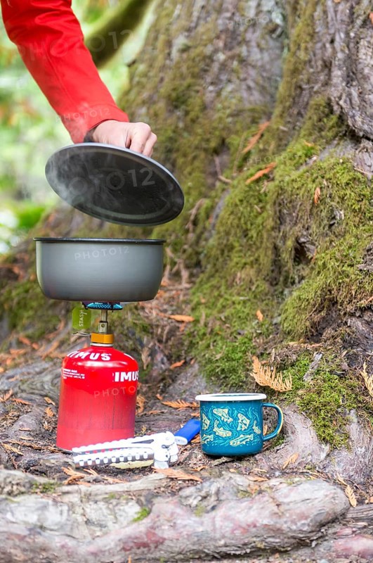Steaming pot stands on camping stove