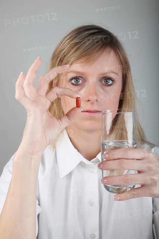 Young woman taking a capsule