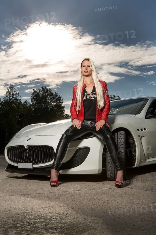 Young woman with long blond hair poses with white Maserati Gran Turismo MC Stradale