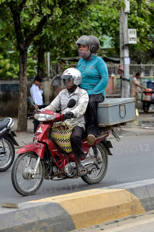 Man on moped and woman sitting on a box