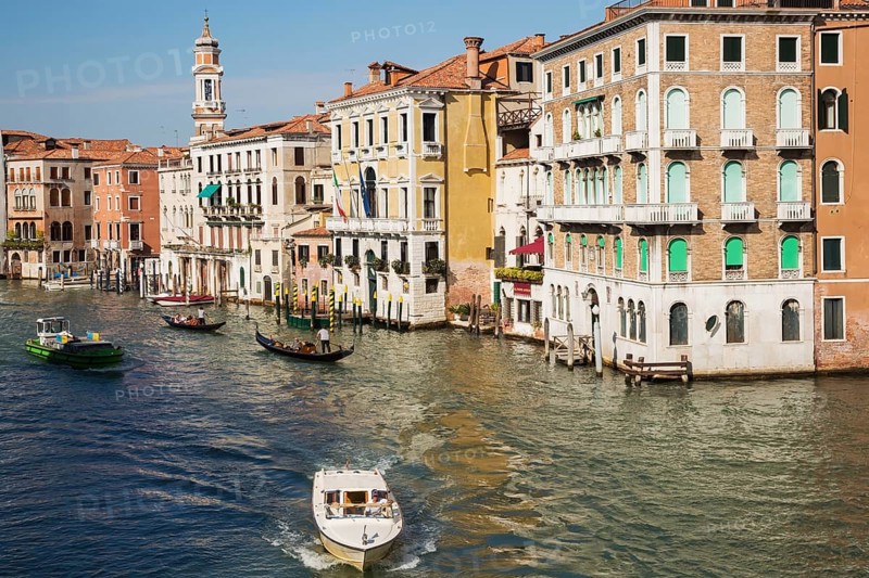Water taxi and gondolas on Grand Canal lined with Renaissance architectural style residential palace buildings
