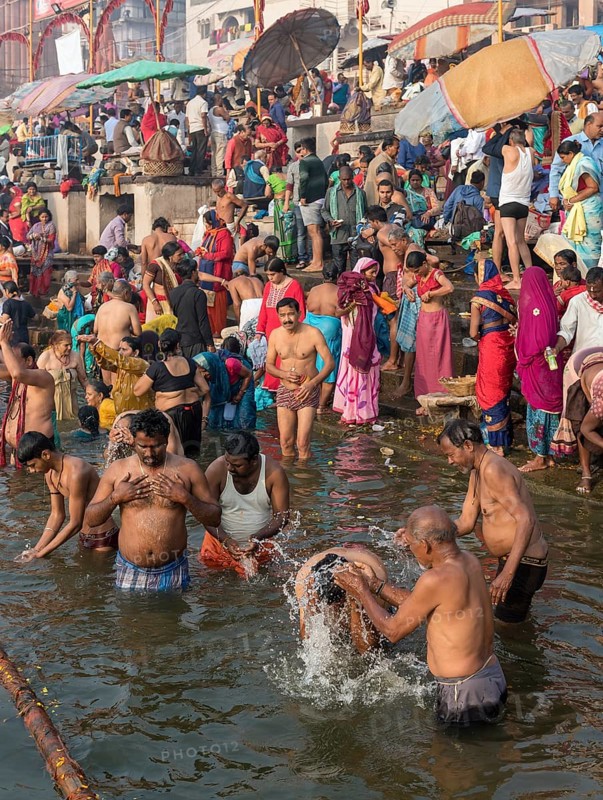 Hindu worshippers perform ritual bath and puja prayers at ghats in the River Ganges